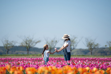 花畑で花を手渡す母と娘
