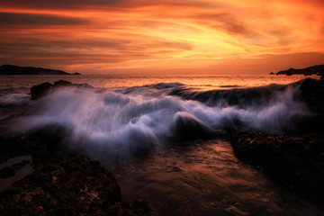 Splash wave over rock in beautiful sky at Kalim Phuket