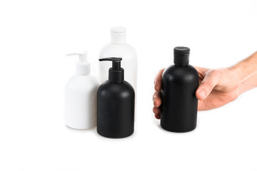 Partial view of man holding cosmetic bottle on white