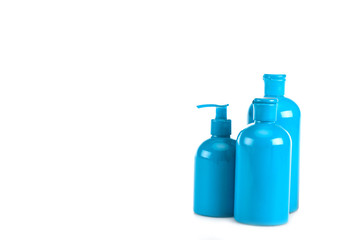 Blue cosmetic bottles with spray and caps isolated on white