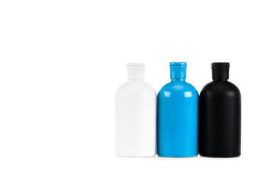 Three colorful cosmetic bottles with caps isolated on white
