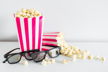 cinema and date concept - close up of two striped boxes with popcorn, 3d glasses and copy space...