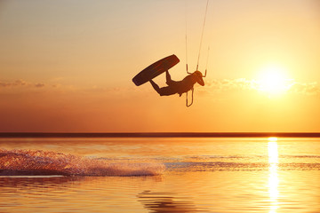 Kitesurfer at sunset with jump - obrazy, fototapety, plakaty