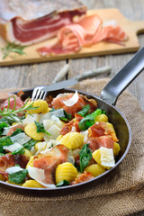 Deftige Pfannen-Gnocchi mit frischem Spinat und knusprig geröstetem Südtiroler Speck in der Eisenpfanne mit Parmesan serviert – Italian Gnocchi with spinach , roasted South Tyrolean bacon and parmesan