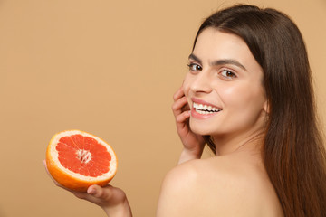 Close up beauty half naked woman 20s with perfect skin nude make up hold grapefruit isolated on...