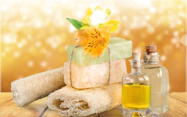 Healthy spa concept with handmade soap bars, oil bottles, sponge and flowers