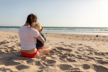 Fototapeta na wymiar Frau mit Kind am Strand blickt aufs Meer