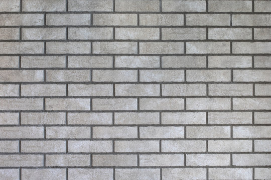 Fototapeta Closeup of modern neutral grey brick wall with dark seams. For pattern, texture and background