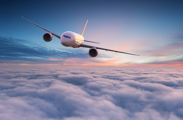 Naklejka na ściany i meble Commercial airplane jetliner flying above dramatic clouds.