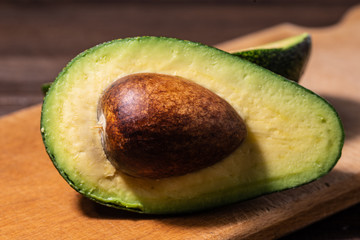 Fresh raw avocado on a cutting board. Top view with copy space.