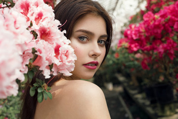 Naklejka premium Beautiful woman portrait with bright makeup looking over her bare shoulder