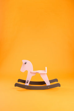 Wooden children's rocking horse on a colored background
