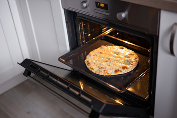 tasty homemade cheese pizza in oven