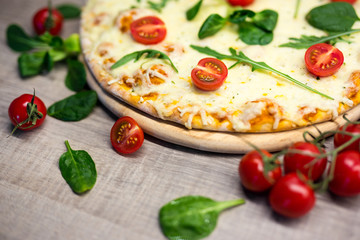 close up of vegetarian pizza with tomatoes and herbs