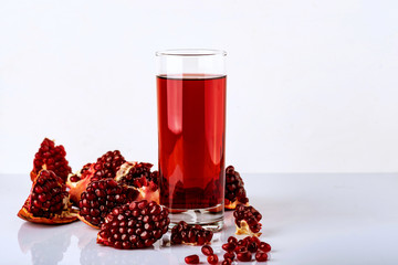 Ripe pomegranate fruit with leaves on white background.