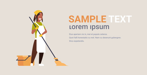Fototapeta premium woman in gloves and apron washing floor african american girl using mop housewife doing housework cleaning concept flat horizontal copy space full length