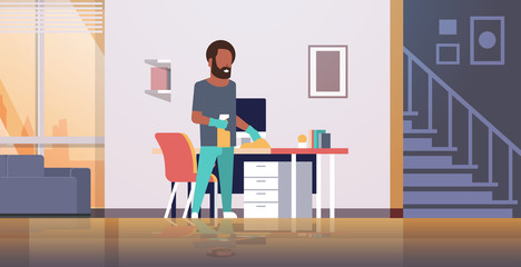 man cleaning computer table with duster african american guy wiping workplace desk housework concept modern living room interior male cartoon character full length horizontal