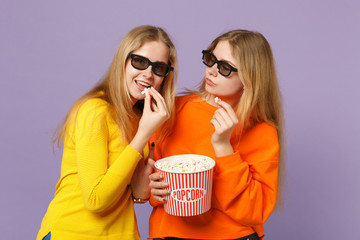 Obraz premium Two cheerful young blonde twins sisters girls in 3d imax glasses