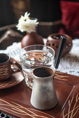 Turkish coffee with glass of water served on table.