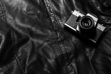 Vintage, antique and old analog camera on leather jacket