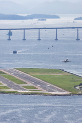 Santos Dumont airport in Rio de Janeiro, airplane taking off, in the background part of the river-niteroi bridge