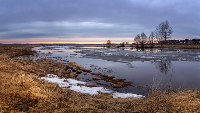 spring sunset panorama with trees on the river Bank and ice, Russia, Ural, April,