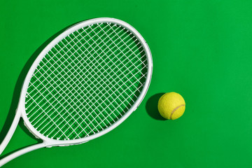 Tennis rackets and ball on blue-green background