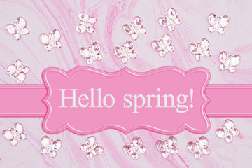 Hello Spring message with pink glass butterflies on pink watercolor paper