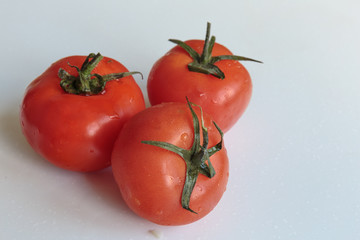 Water drops on a fresh ripe tomatoes. Vegan food.