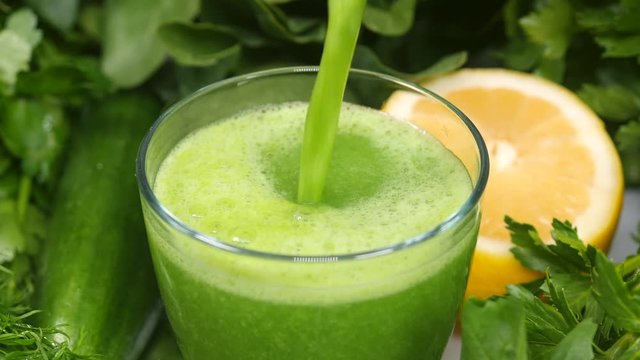 Pouring healthy green cocktail into a glass