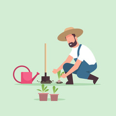 male farmer planting young seedlings plants flowers and vegetables man working in garden agricultural worker in uniform eco farming concept flat full length