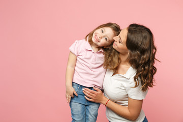 Woman in light clothes have fun with cute child baby girl. Mother, little kid daughter isolated on pastel pink wall background, studio portrait. Mother's Day, love family, parenthood childhood concept