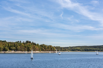 Fototapeta na wymiar Ein sonniger Tag am See voller Wassersportler und Segelboote
