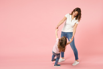 Woman in light clothes have fun with cute child baby girl. Mother, little kid daughter isolated on...