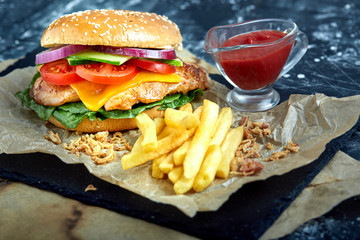 Delicious burgers with beef, tomato, cheese and french fries with tomato sauce