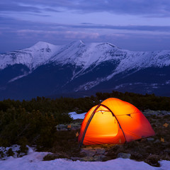 Red tourist tent in spring mountains
