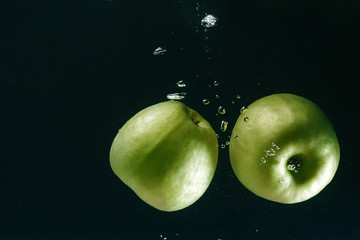 image of an Apple in water bubbles on a dark background
