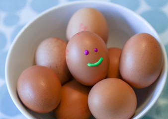 Easter eggs with happy faces in the pebble on the table