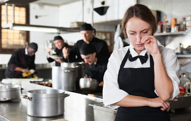 Tired and upset waitress in kitchen of restaurant