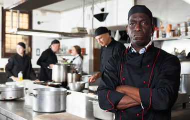 Aafrican american confident chef male in kitchen of restaurant