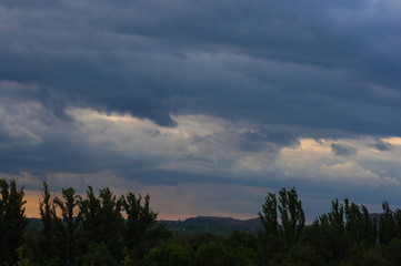 Landscape with dramatic light - beautiful golden sunset with saturated sky and clouds.