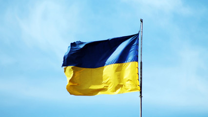 big Ukrainian flag against the background of a bright clear blue sky 