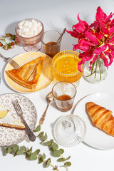 Lemon and pear pie on color plates on the table with coffee, sugar and honey. Table setting.