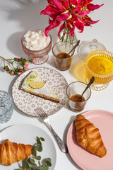 Lemon and pear pie on color plates on the table with coffee, sugar and honey. Table setting.