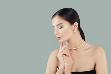 Beauty portrait of elegant model woman in pearls necklace and earrings
