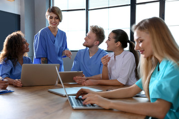 Group of smart medical students with gadgets in college