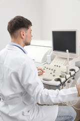 Fototapeta na wymiar Sonographer operating modern ultrasound machine in clinic