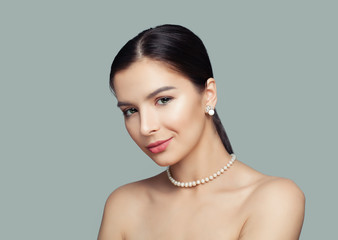 Beautiful woman with healthy skin wearing white pearls jewelry necklace