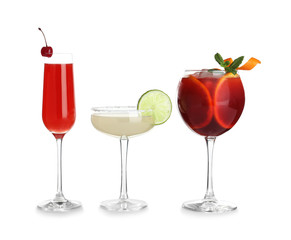 Glasses of traditional alcoholic cocktails on white background