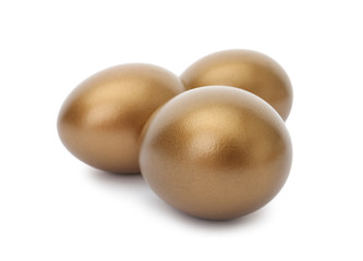 Three shiny golden eggs on white background